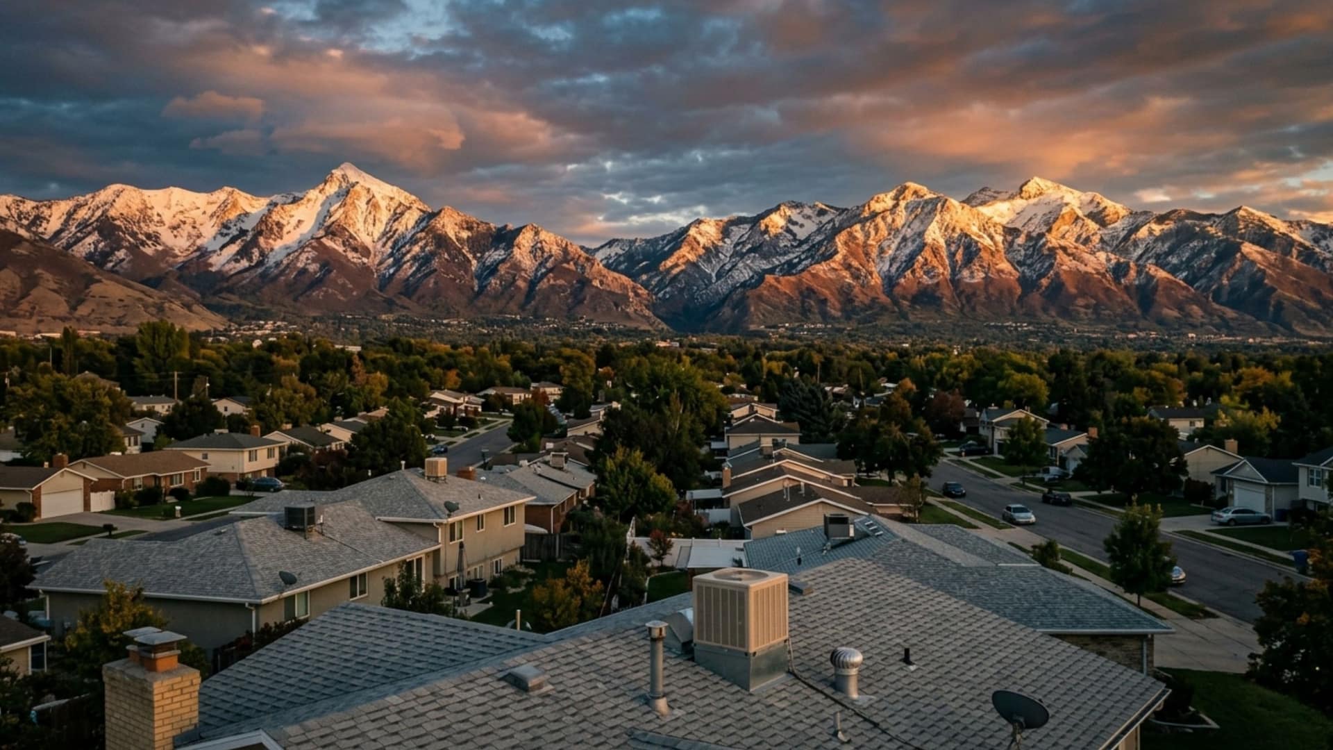 Wasatch mountain range over Murray, Utah rooftops at golden hour